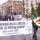 A group of people walking down a street with sign that reads “Commémoration du génocide contre les Tutsi du Rwanda. Avril-Juillet 1994. www.pagerwanda.ca”.