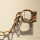 Rusted iron manacles hang on hooks on a plain white wall.