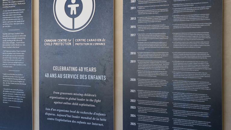 Large dark blue panels with white text and graphics displayed in the Community Corridor at the Canadian Museum for Human Rights. The centre panel features a circular logo and commemorates the 40th anniversary of the Canadian Centre for Child Protection. The two panels on either side present bilingual text in English and French.