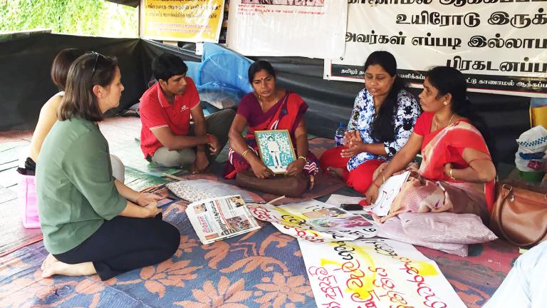 In the Sri Lankan city Vavuniya in 2017, Elaine Pearson meets with Tamil mothers protesting the enforced disappearance of their children during Sri Lanka's civil war. Partially obscured.