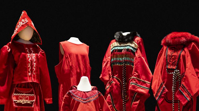 5 red dresses of different sizes and designs are displayed on mannequins. Partially obscured.