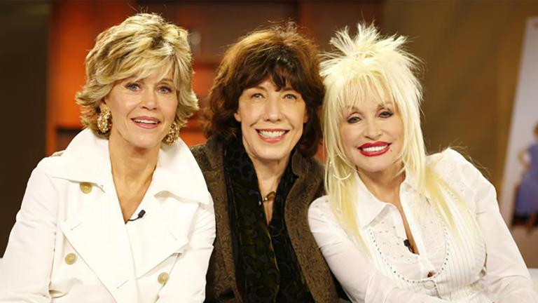 Jane Fonda, Lily Tomlin and Dolly Parton sitting on a couch together. Partially obscured.