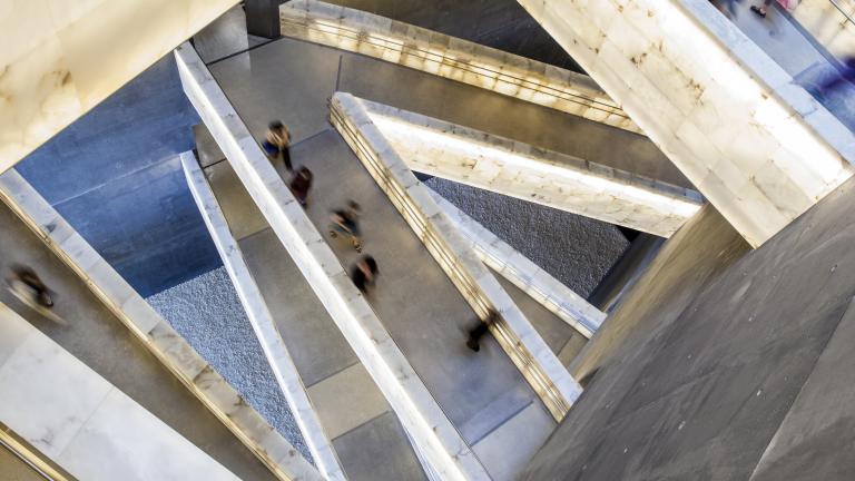 Looking down through the Museum’s criss-crossing alabaster ramps as people move through them. Partially obscured.