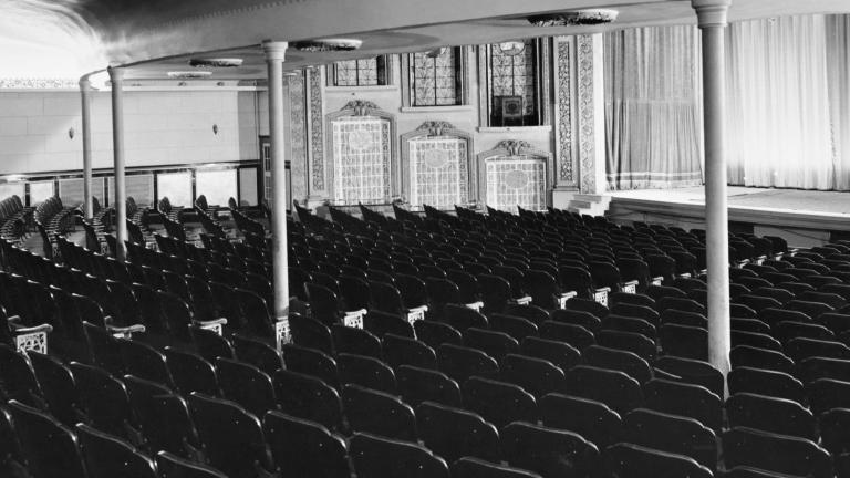 A black and white photograph of the interior of an empty, old-fashioned theatre.