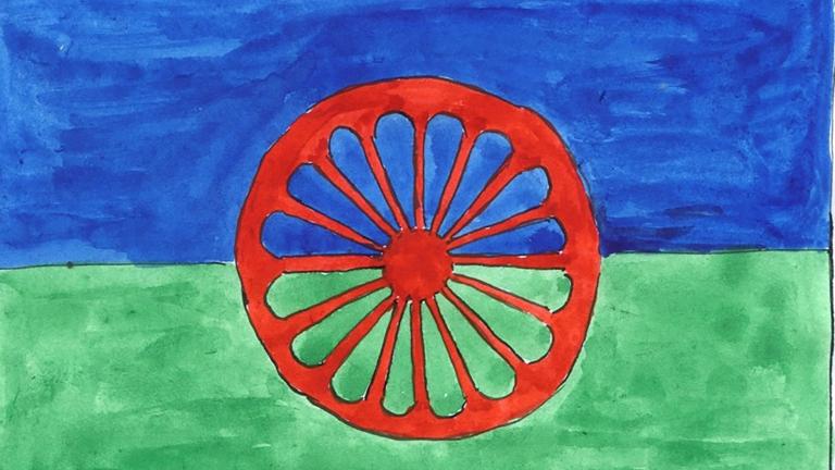 A painting of the Romani flag, which is blue on top, green on the bottom and has a red chakra that looks like a wagon wheel in the centre. Partially obscured.