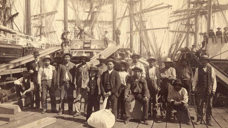 A group of men standing on a shipping dock and posing for a photo.