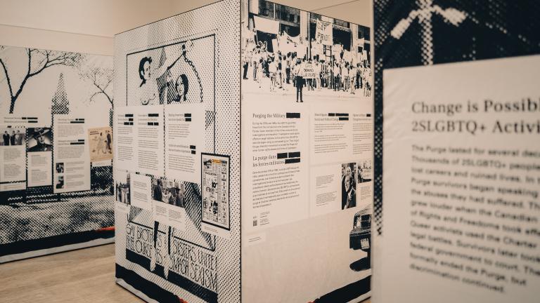 A pop-up exhibition showing three separate black and white cube-shaped panels. The closest one displays "Change is possible." Partially obscured.