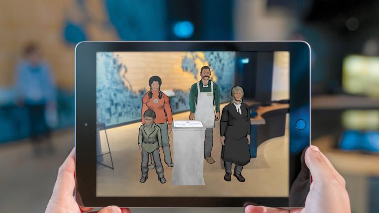A visitor's hands hold a tablet that carries an image of four animated people including a little boy, a young Indigenous woman, a man wearing an apron and a woman judge.