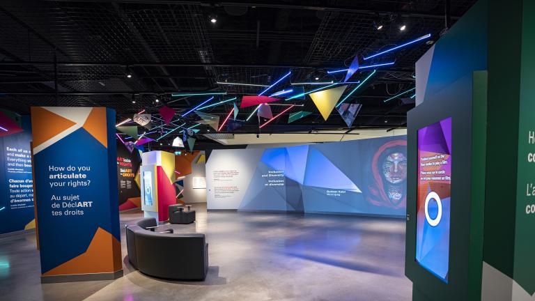 A museum gallery featuring artwork projected onto large screens and colourful geometric shapes.