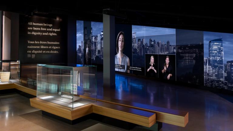 A gallery with exhibit display cases and visitor benches.