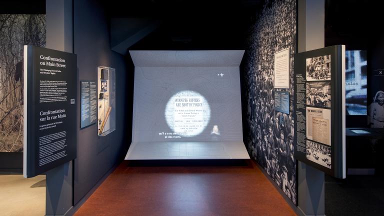 A Museum display including photos, text and large video display that has captions and sign language interpretation.