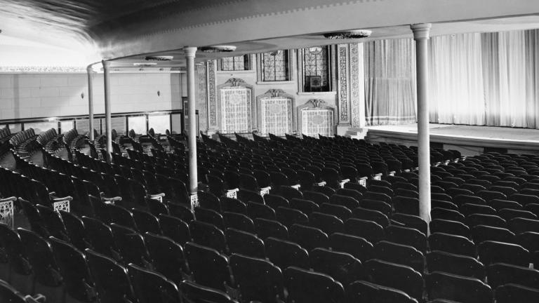A black and white photograph of the interior of an empty, old-fashioned theatre.