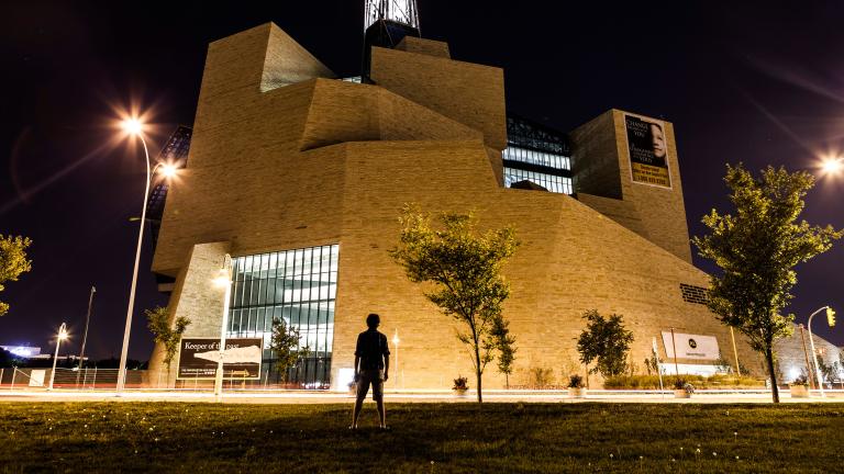  A silhouette of a person faces the exterior north side of the Museum at night (the limestone mountain).