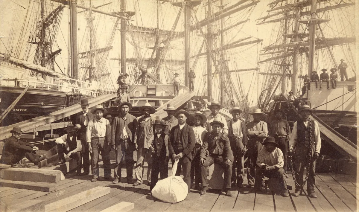 A group of men standing on a shipping dock and posing for a photo.