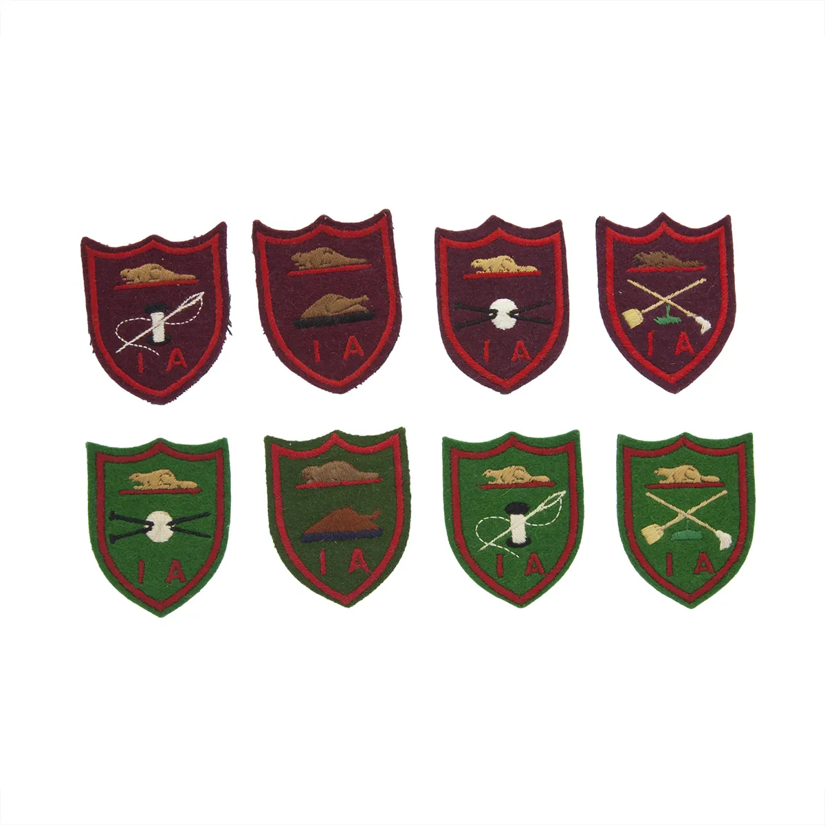 Eight fabric dark red and dark green badges placed in two rows. They have embroidered designs on them such as a needle and thread, gardening tools and knitting needles.