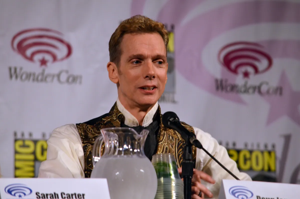 A man sits at a microphone.