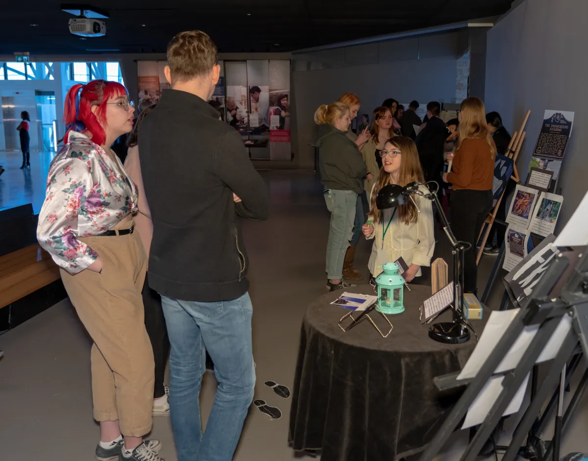 A group of people looking at a display of art.