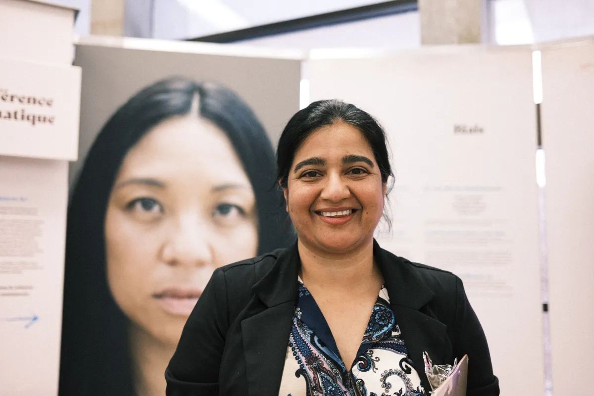 A woman stands in front of information panels presenting text and a large photograph.