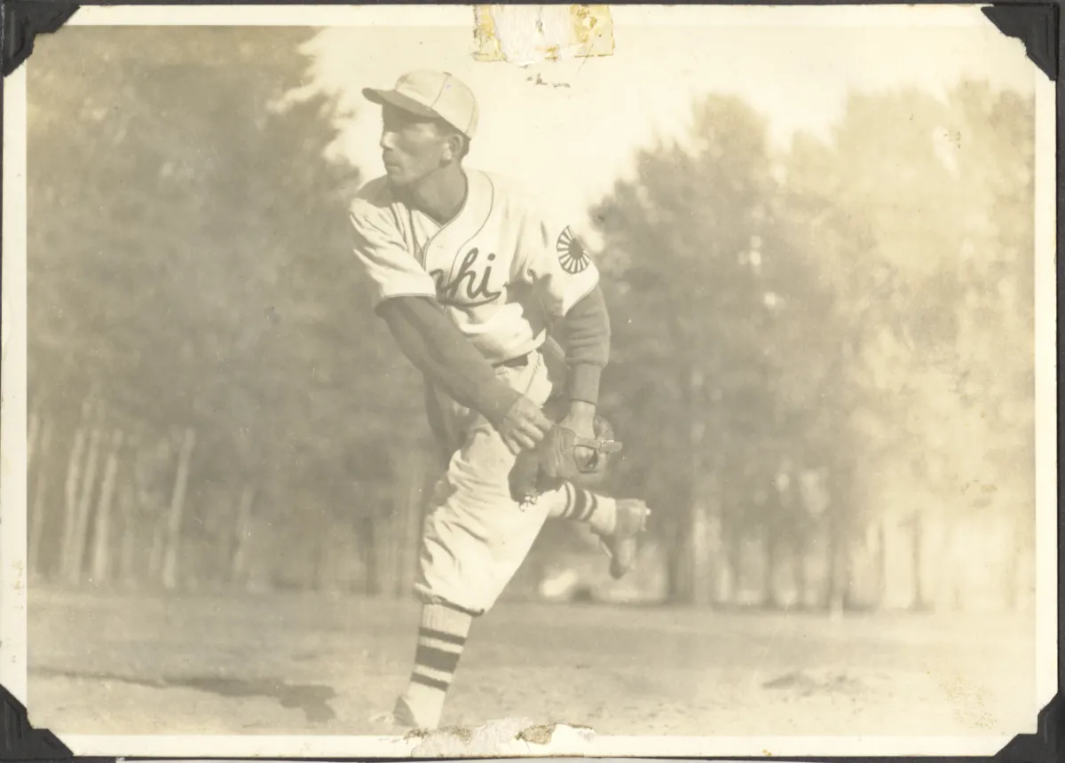 A young man in baseball uniform throwing a pitch.