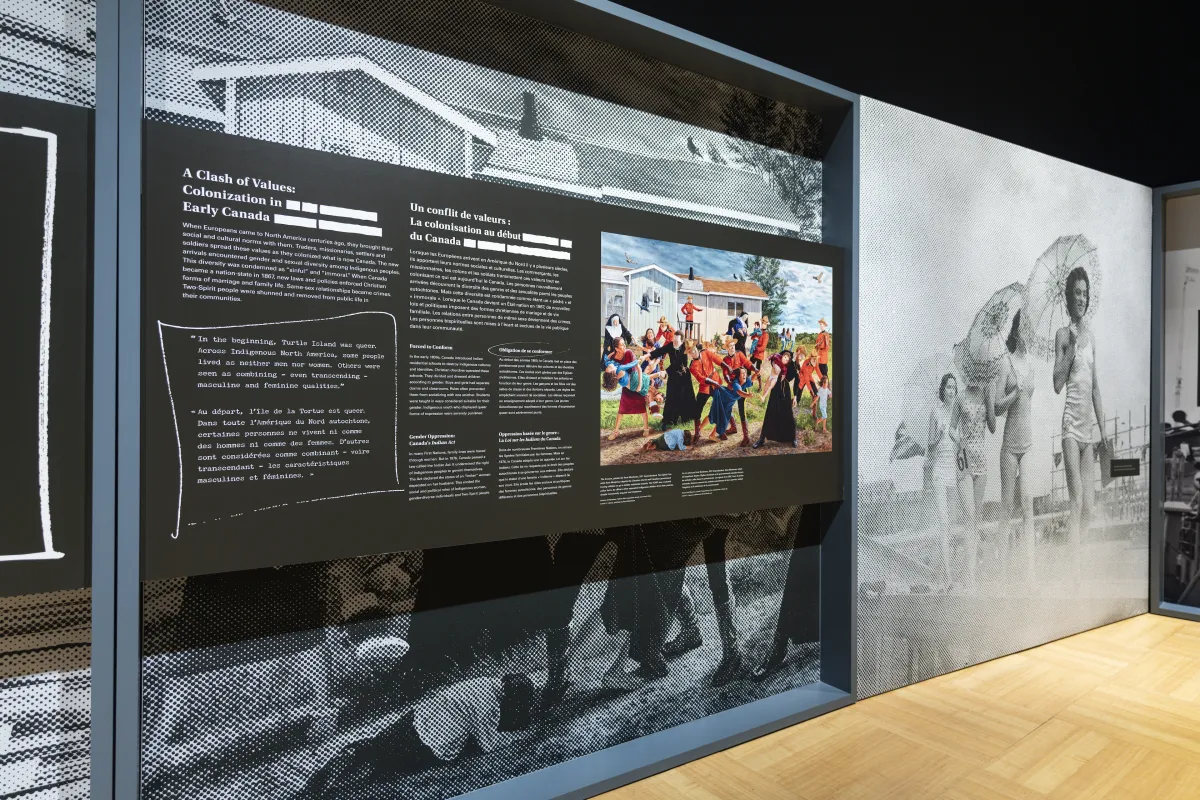 A large exhibit panel on the left features the words “A Clash of Values: Colonization in Early Canada” and a colourful painting. On the right, there is a large black-and-white photograph of people parading in single file in 1940s women’s swimsuits.