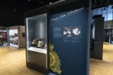 A display case featuring a Stetson hat and magazines is to the left of an exhibition panel with photographs, text, and the words “Dave Van Norman.”
