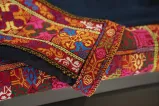 A closeup of a colourful embroidered fabric. The pattern is a traditional Palestinian embroidery called tatreez.