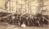 A group of men standing on a shipping dock and posing for a photo.