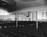 A black and white photograph of the interior of an empty, old-fashioned theatre.