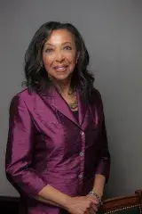 A Black woman smiles at the camera.