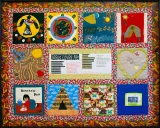 A colourful quilt with varied panels, including designs such as a bird, a heart, a teepee, a woman cleaning a floor, and lines of text under the title “Jesus Loves Me.”