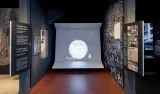 A Museum display including photos, text and large video display that has captions and sign language interpretation.