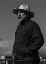 Man with a cowboy hat. Photographed in black and white.