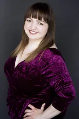 Renate Rossol, a brown-haired, brown-eyed woman, is smiling broadly. She is wearing a bright fuchsia cocktail dress.