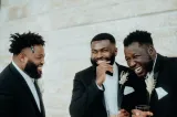 Three men laughing in tuxedos.