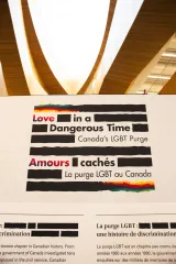 Text from a display about Canada's LGBT Purge, featuring the title “Love in a Dangerous Time” and “Amours cachés,” with sections discussing discrimination and historical context, illustrated with rainbow colours.