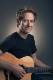 A man plays an acoustic guitar.