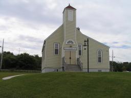 An image of a wooden church building with a single steeple. Above the main doors is a sign that reads “Seaview United Baptist Church.”