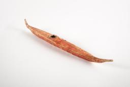 A long, thin, reddish-brown toy canoe.