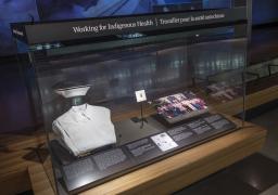 A museum display case labelled “Working for Indigenous Health” and containing a nurse’s uniform, a graduation pin and a group photo.