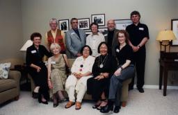 A posed group shot of several people sitting and standing. 