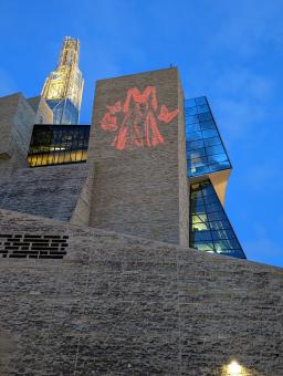 The image of a red dress flanked by red butterflies is projected on a limestone façade on the exterior of the Canadian Museum for Human Rights.