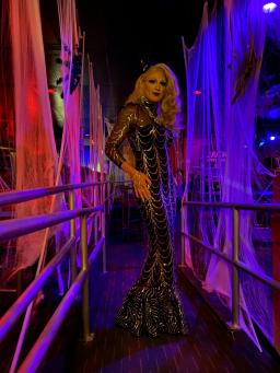 A drag queen elegantly dressed in a long, black glam gown.
