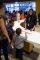 Museum visitors of all ages are writing on cards and talking to one another around a curved table.