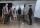 A small group of people stand in a semicircle in front of large screen displays.