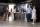 Small groups of people stand in a Museum exhibition space and talk to one another.