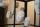 Several white plaster faces hang from strings, inside a cage.