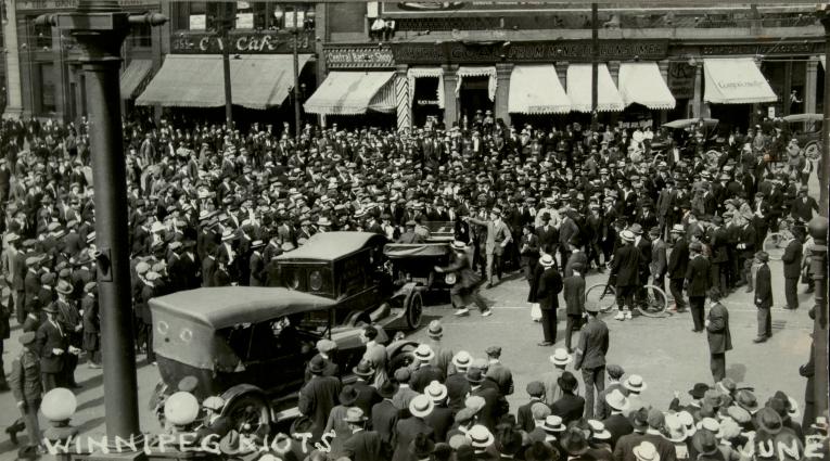 A large crowd gathered on a street Partially obscured.