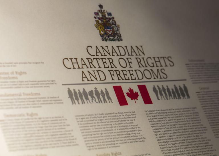 A close up of the Canadian Charte of Rights and Freedoms Partially obscured.