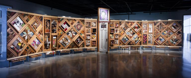 Large artwork consisting of objects set in cedar frames. Partially obscured.