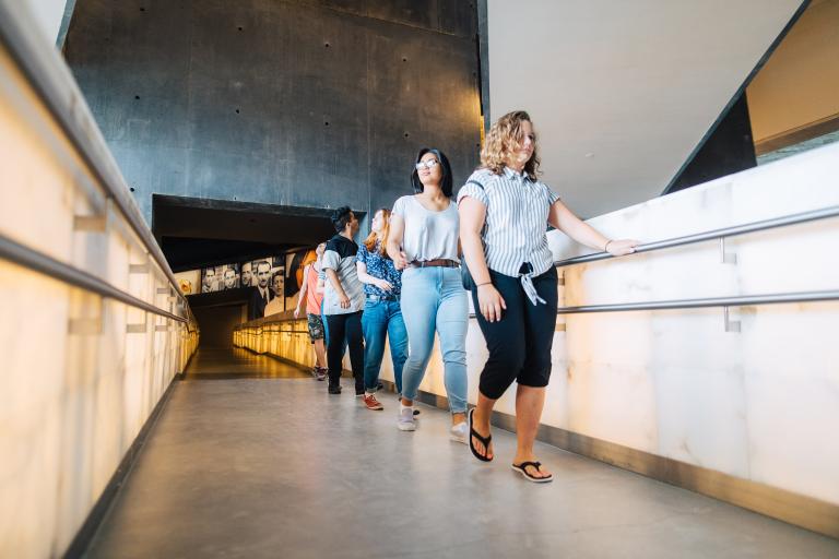 Students in a line walking on the ramp. Partially obscured.